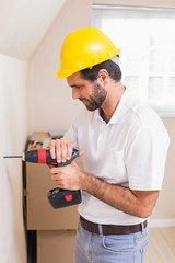 Construction worker drilling hole in wall