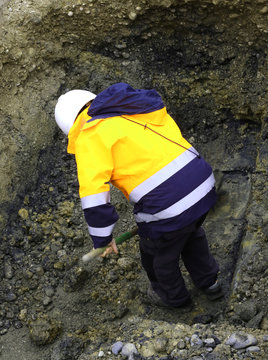 worker during roadwords underground with yellow jacket
