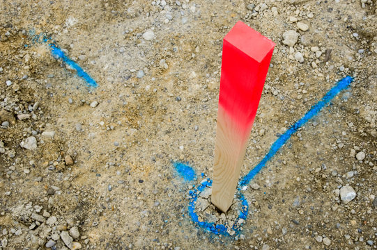 Pflock und blaue Markierung auf Baustelle