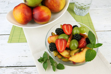 fresh tasty fruit salad on wooden table