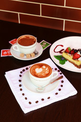 Cup of coffee with cute drawing in cafe