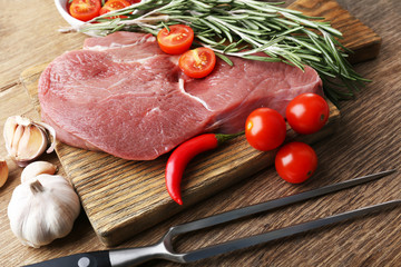 Raw beef steak on wooden table