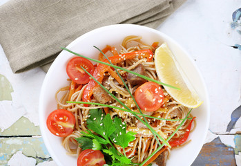 Chinese noodles with vegetables and roasted meat in bowl