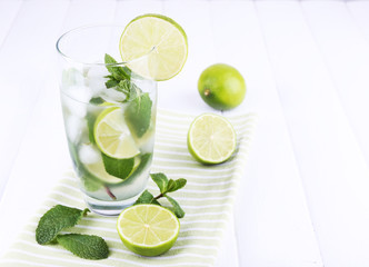 Lemonade in glass on napkin on bright background