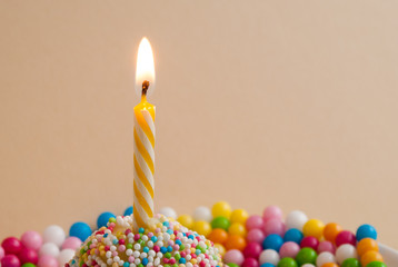 Yellow candle with colourful sweets