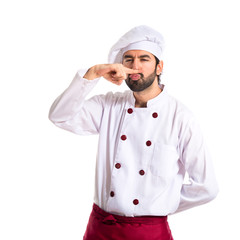 Chef doing moustache gesture over shite background