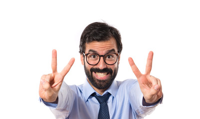 Businessman doing victory gesture over white background