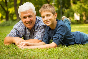 Naklejka na ściany i meble Grandfather and grandson in the park