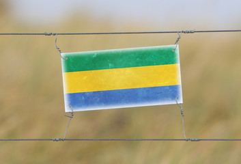 Border fence - Old plastic sign with a flag