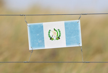 Border fence - Old plastic sign with a flag