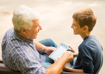 Obraz premium Grandfather and grandson in the park