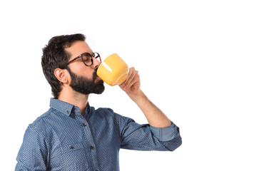 Fototapeta premium Young hipster man drinking coffee over white background