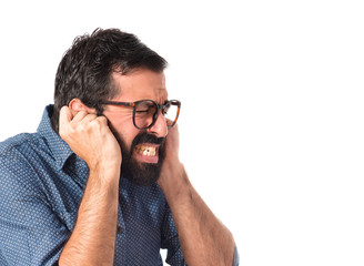 Young hipster man covering his ears