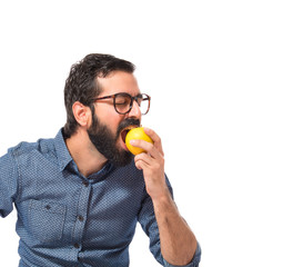Young hipster man eating apple over white background