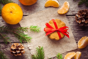 Fototapeta na wymiar Gingerbread Cookie with mandarins on Christmas background
