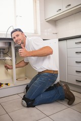 Plumber fixing under the sink