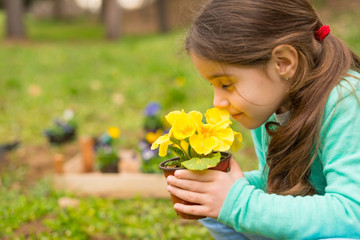 Little girl smells flowers