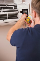 Focused handyman testing air conditioning