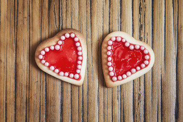 Fototapeta na wymiar Two red hearts cookies on wooden background