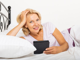 Happy mature woman with electronic book