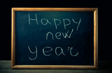 inscription "Happy new year" in chalk on the blackboard