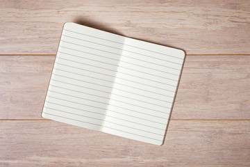 Top view of open note book on wooden background