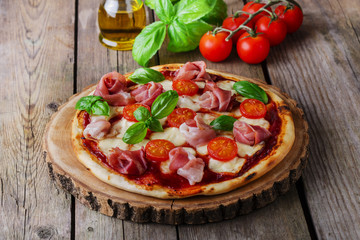 pizza with mozzarella and prosciutto, tomatoes