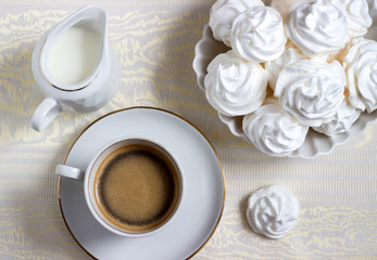 meringue cookies and a cup of coffee with cream