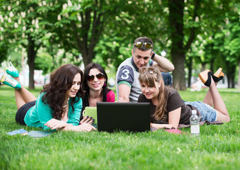 Group of young college students sitting on grass