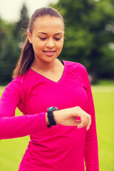 smiling young woman with heart rate watch