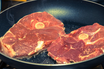 steaks grilling in a pan