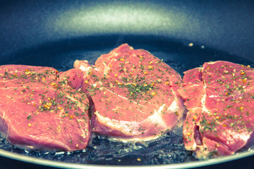 steaks grilling in a pan