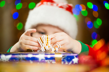boy holding holiday ribbon on a present box