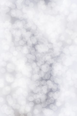 Silver festive glitter background with defocused lights