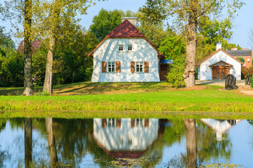 Fototapeta na wymiar Lake and typical cottage houses in Radziejowice village, Poland