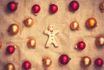 Gingerbread man with color balls on jute background.