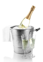 Bottle of champagne in metal ice bucket and two glasses