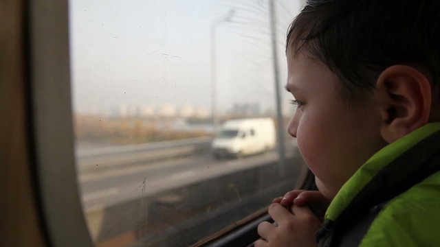 boy looking out the window at the cars in the metro 3