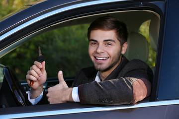 Man with car key in car