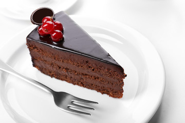 Delicious chocolate cake on plate on table on light background