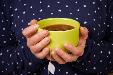 Female hands holding a cup of tea