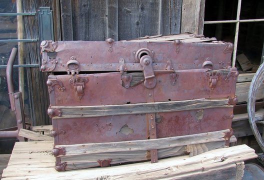 Old chest  displayed on the side of a barn