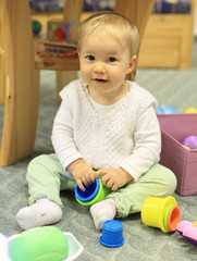 Young cute child playing on floor indoor