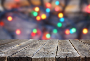 Fototapeta premium rustic wood table in front of glitter colorfull bright bokeh lig