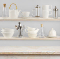 Fototapeta na wymiar Wooden table over background of shelves with kitchen utensils