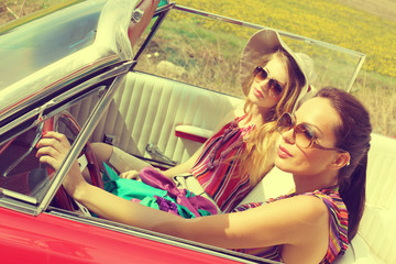 Beautiful women driving a red retro vintage car