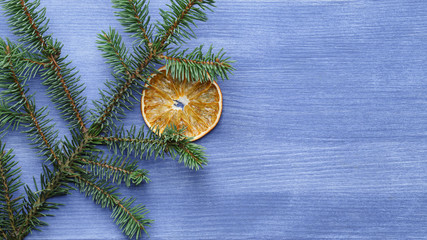 Fototapeta na wymiar christmas tree branch on blue wood table