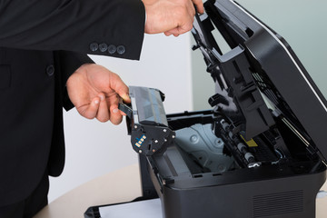 Businessman Fixing Cartridge In Photocopy Machine