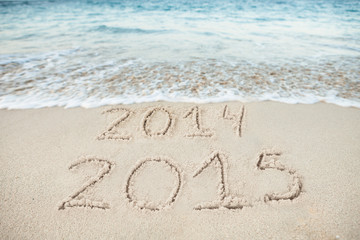 Surf Rushing Towards 2014 And 2015 Drawn On Sand