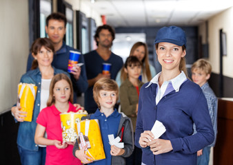 Happy Worker With Families In Background At Cinema